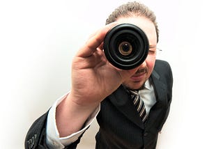 A man looking through a magnifying glass.