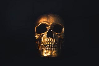 A golden skull shining against a dark background — read to the end of the piece and it will all become clear!