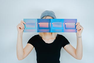 A woman hides her face behind a screenprint.