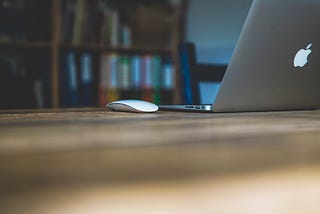 Mouse and laptop on a desk.