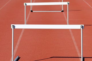 A picture of hurdles lined up in a lane on a track.