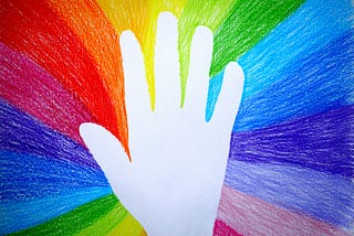 silhouette of a hand on a rainbow background