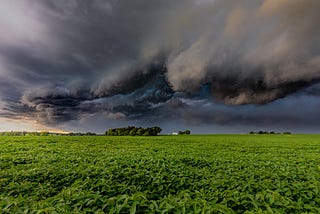 Thunderstorm clouds rolling over a field.