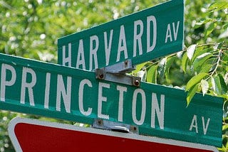 Two signs at an intersection read ‘Harvard Av’ and ‘Princeton Av’