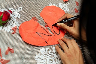 A heart shape paper with text “No”