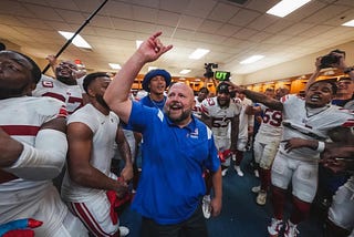 Giants head coach Brian Daboll celebrating with the team post-victory.