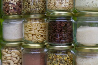 Stacks of clear glass jars with various types of food inside.