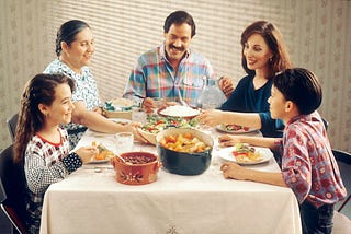 family sitting around the table, eating dinner