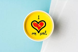 an image shows “I love my job” in a coffee mug