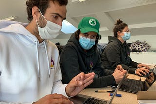 Three Botify Engineers working on their laptops next to each other.