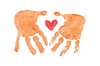 two hand prints encircling a red heart