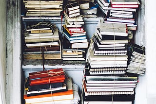 Bookshelves piled with bound notebooks