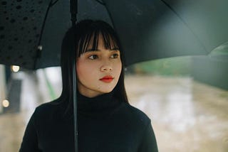 photo of woman holding black umbrella
