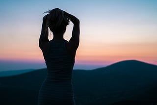 Silhouette of a woman on top of a hill