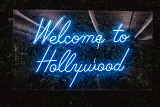 A blue and white Welcome To Hollywood sign with a black border