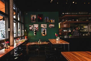 dark interior of a coffee shop/restaurant with wooden tables