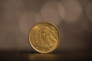 An Irish 20 cents of euro coin standing on a surface.