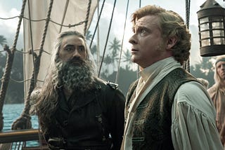 Blackbeard (Taika Waititi) and Stede Bonnet (Rhys Darby) stand on the deck of a pirate ship in a scene from Our Flag Means Death