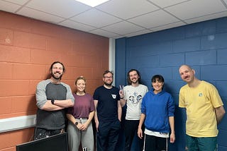 Five members of FreeAgent’s Radar team standing in front of the walls that they painted
