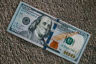 A Americal $100 note on the pavement