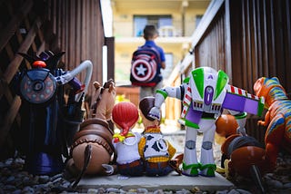 Toy Story characters; out of focus: a boy carrying a Captain America backpack.