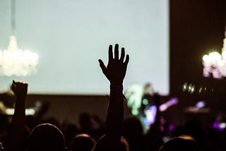 A hand raised in an audience