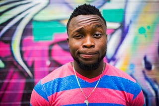 A young, Black man looking into the camera.