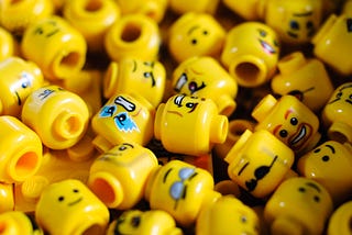A large number of head-shaped lego blocks (representing lots of employees in a large company)