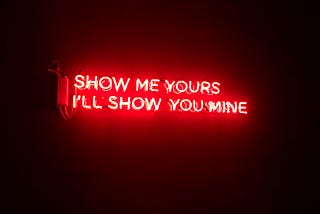 Neon light saying “Show me yours I’ll show you mine”