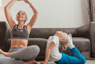 Beautiful baby boomer mum and daughter doing yoga