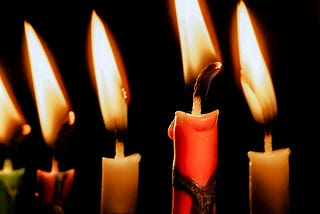 Candles burning in front of a black background