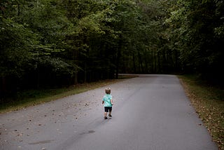 kid running away down a road