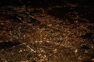 A cityscape at night time with all streets, alleys and roads illuminated