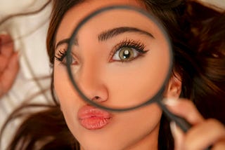 A woman looking through a magnifying glass
