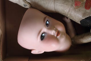 Severed head of a bald porcelain doll with eyes glaring