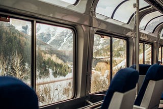 View out of the window from a train observation car, showing passing terrain