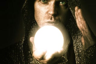 Hooded man holding a glowing ball in his hand