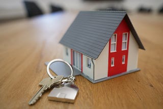 A miniature model of a house with a key.