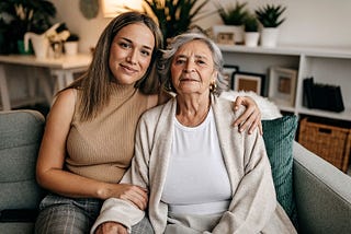 Senior woman and her grandmother sitting together in living room