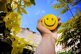 Image: Holding up a smile | How to Be an Expert in Happiness — an article by Joshua Casey-Wytt