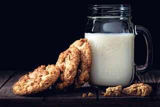 Almond milk in a lass jug and oatmeal cookies.