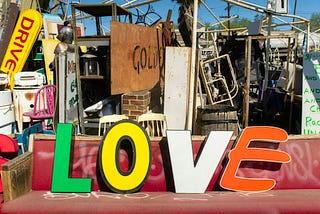 Pile of junk and word LOVE on the bench.