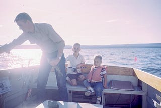A father on a fishing boat with his two kids