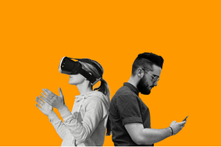 An image of a couple standing back to back. The female on the left is wearing a VR headset and is absorbed into a virtual world. The male on the right is looking at his phone and is absorbed into a different kind of virtual world. The images are grayscale and set against an orange background.