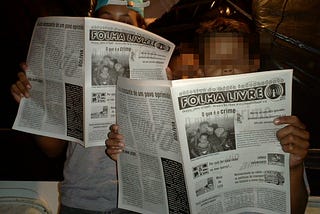 Young boys reading an Indymedia Newspaper called “Folha Livre” (Free — as in freedom — News)