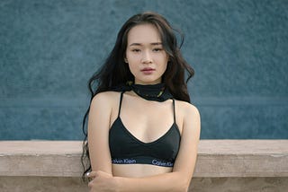 Yuung Japanese woman with bare midrift in halter top and jeans.