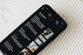 Photograph of smartphone with news items on screen