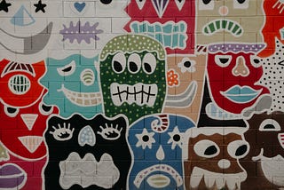 wall covered in graffiti of unusual faces