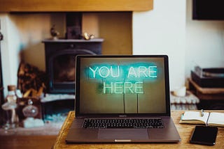 Open laptop on a desk with the words “You are here” on the screen