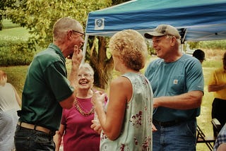 Group of older people smiling at a reunion